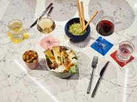 a white table with a bowl of food and glasses of wine at Tribe Paris Saint Ouen in Saint-Ouen