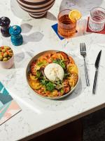 a bowl of pasta with an egg on a table at Tribe Paris Saint Ouen in Saint-Ouen