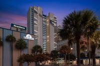 ein großes Gebäude mit Palmen davor in der Unterkunft SpringHill Suites by Marriott Myrtle Beach Oceanfront in Myrtle Beach