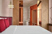 a bedroom with a large white bed with red pillows at W Dubai - Mina Seyahi in Dubai