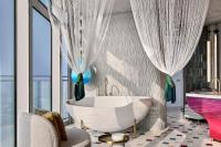 a bathroom with a tub and a large window at W Dubai - Mina Seyahi in Dubai