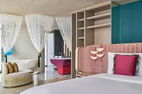 a bedroom with a large bed and a tub and a bedroom with a bed at W Dubai - Mina Seyahi in Dubai