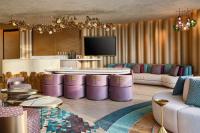 a living room with purple furniture and a tv at W Dubai - Mina Seyahi in Dubai