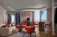 a living room with a white couch and red chairs at W Dubai - Mina Seyahi in Dubai