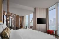 a hotel room with a large bed and a television at W Dubai - Mina Seyahi in Dubai
