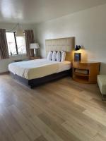 a hotel room with a bed and a desk and a couch at The Virginian Inn Moab Downtown in Moab