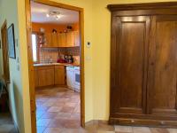 a kitchen with yellow walls and a wooden door at La Peyreyre in Jaujac