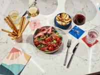 a white table with a bowl of food and glasses of wine at Tribe Paris Saint Ouen in Saint-Ouen
