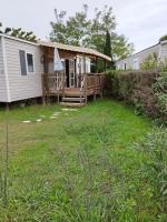 a mobile home with a porch and a deck at mobil home lac des reves in Lattes