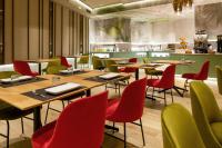 Un restaurante con mesas de madera y sillas rojas. en Melia Plaza Valencia, en Valencia