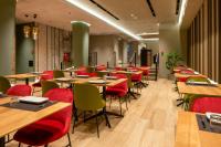 Un restaurante con mesas de madera y sillas rojas. en Melia Plaza Valencia, en Valencia