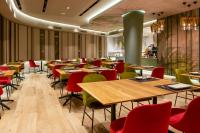 Un restaurante con mesas de madera y sillas rojas. en Melia Plaza Valencia, en Valencia