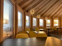 ein Esszimmer mit Tischen, Stühlen und Fenstern in der Unterkunft Imago Village in Saint-David-de-Falardeau