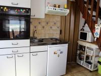 a kitchen with white cabinets and a sink and a microwave at Maison Port-la-Nouvelle, 1 pièce, 2 personnes - FR-1-229C-753 in Port-la-Nouvelle