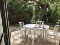 a white table and chairs on a patio at Vacances entre Bormes et Le Lavandou in Bormes-les-Mimosas