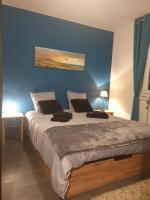 ein Schlafzimmer mit einem großen Bett mit blauer Wand in der Unterkunft Chambre individuelle Jules in Agen