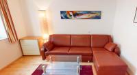 a living room with a brown couch and a glass table at Bauernhofpension Herzog zu Laah in Linz