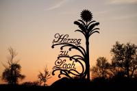 a sign with a palm tree in the sunset at Bauernhofpension Herzog zu Laah in Linz