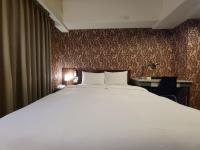 a large white bed in a room with a wall at The Galerie Hotel in Taichung