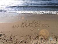 a message written in the sand on the beach at Appartement Le Grau-du-Roi, 3 pièces, 6 personnes - FR-1-250-61 in Le Grau-du-Roi