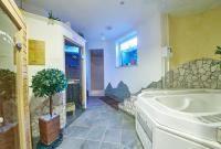 a bathroom with a tub and a potted plant at Hotel Gamshag in Saalbach-Hinterglemm