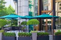 a group of tables with blue umbrellas in front of a building at Conrad Shanghai in Shanghai