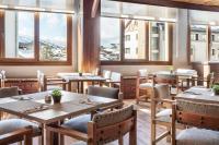 シエラネバダにあるMelia Sierra Nevadaのテーブルと椅子と窓のあるレストラン