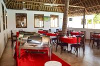 Un comedor con mesas y sillas rojas. en Sheratton Beach Villagio, en Mombasa