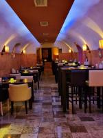 un restaurante con una fila de mesas y sillas en Fantastico Exlcusive Hotel, en Senta