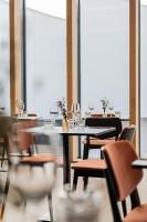 a dining room with tables and chairs with wine glasses at Afterwork Hotel in Etoy