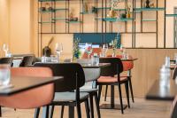 a restaurant with tables and chairs with wine glasses at Afterwork Hotel in Etoy