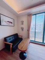 a living room with a black couch and a wooden table at Blue Sea Inn in Eluan