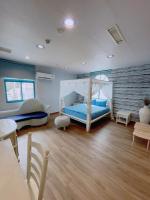 a bedroom with a blue bed and a wooden floor at Blue Sea Inn in Eluan