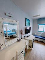 a room with a bedroom with a bed and a mirror at Blue Sea Inn in Eluan