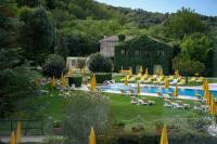 un complejo con piscina con sillas y sombrillas en Terme Preistoriche Resort &amp; Spa, en Montegrotto Terme