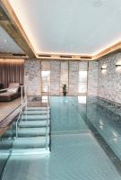 a swimming pool with a glass floor in a house at Bergdorf Hotel Zaglgut in Kaprun