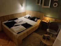 a bedroom with a bed with two pillows and a chair at Kineski zid in Zenica