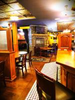 Un restaurante con mesas y sillas y una chimenea. en Royal Duke Hotel, en Okotoks