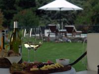 a bottle of wine and a plate of cheese and wine glasses at Lares De Chacras in Chacras de Coria