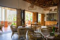 a restaurant with wooden tables and chairs and windows at Casa Nemo Beach Resort & Spa in Sabong