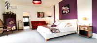 a bedroom with a bed and a red chair at Domaine du Châtelard in Dirac