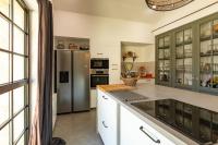 a kitchen with white cabinets and a stainless steel refrigerator at Mas des Coteaux - vue panoramique - piscine - babyfoot - pingpong - pétanque &amp; espace enfants à 1h de MONTAUBAN in Gramont