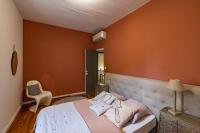 a bedroom with a large bed with orange walls at Mas des Coteaux - vue panoramique - piscine - babyfoot - pingpong - pétanque &amp; espace enfants à 1h de MONTAUBAN in Gramont