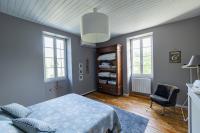 a bedroom with a bed and a chair and windows at Mas des Coteaux - vue panoramique - piscine - babyfoot - pingpong - pétanque &amp; espace enfants à 1h de MONTAUBAN in Gramont