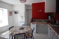 a kitchen with a table and a red wall at Le coudert in Limoges