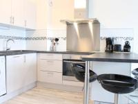 a kitchen with white cabinets and a counter with stools at Appartement La Rochelle, 2 pièces, 4 personnes - FR-1-246-207 in La Rochelle
