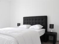 a white bed with a black headboard and two pillows at Appartement La Rochelle, 2 pièces, 4 personnes - FR-1-246-160 in La Rochelle