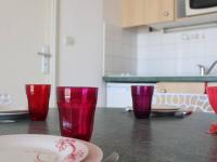 three red glasses sitting on a table in a kitchen at Appartement La Rochelle, 2 pièces, 4 personnes - FR-1-246-286 in La Rochelle