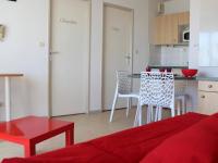 a living room with a red couch and a kitchen at Appartement La Rochelle, 2 pièces, 4 personnes - FR-1-246-286 in La Rochelle