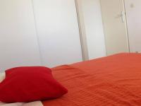a red pillow sitting on top of a bed at Appartement La Rochelle, 2 pièces, 4 personnes - FR-1-246-286 in La Rochelle